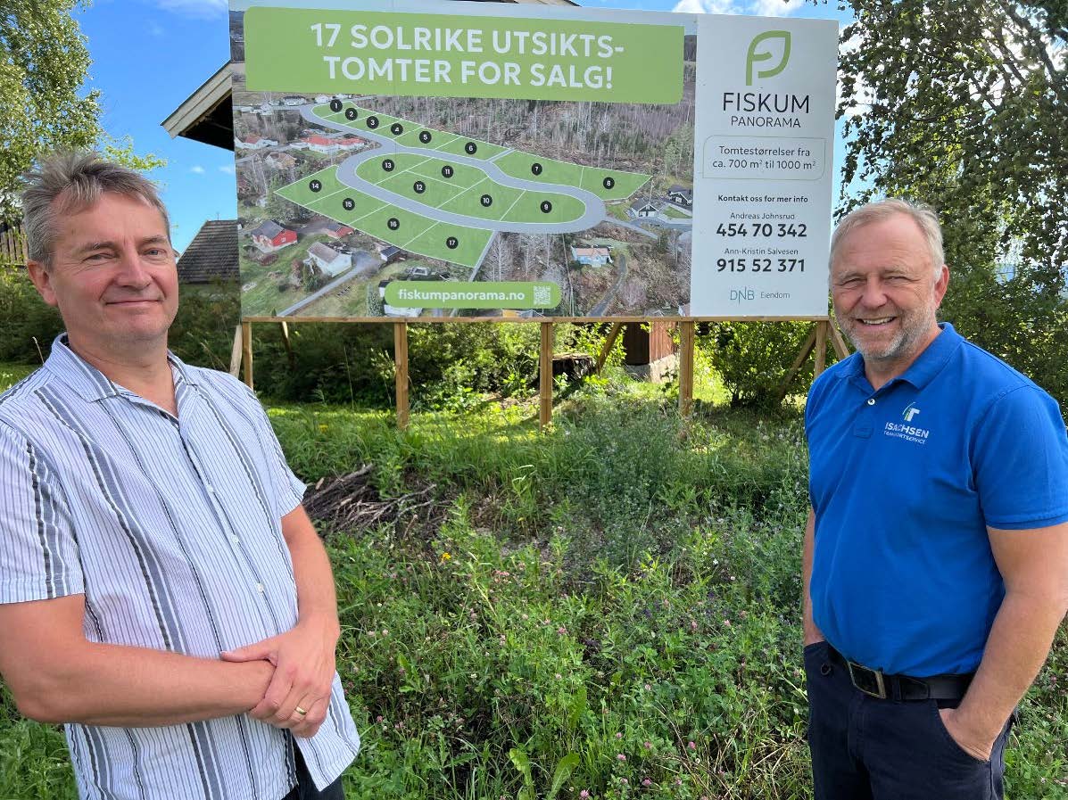 Kim Lande og Rune Isachsen foran et skilt av de 17 tomtene på Fiskum Panorama. Foto.